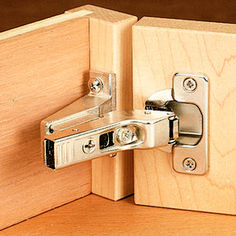 a close up of a door hinge on a wooden surface