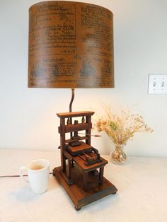 a lamp that is sitting on top of a table next to a cup and saucer