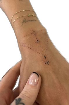 a woman's hand with tattoos on it and a star tattoo on the wrist