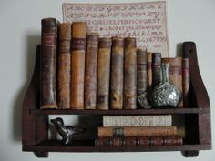 an old book shelf with many books on it and a bird figurine next to it