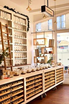 a room filled with lots of shelves and jars on top of wooden shelves next to windows