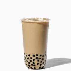 a cup with black dots on it sitting next to a white wall