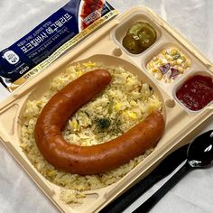 a hot dog and rice with condiments on a tray