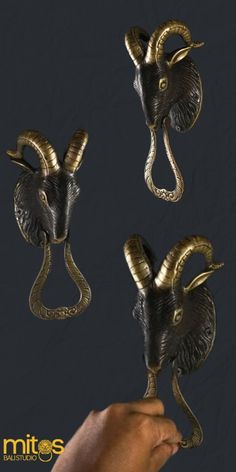 three brass rams with long horns are shown in the shape of an animal's head