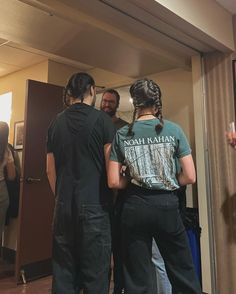 three people standing in front of a mirror