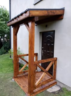 a wooden gazebo sitting in front of a house