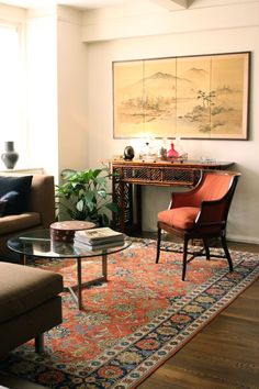 a living room filled with furniture and a painting on the wall