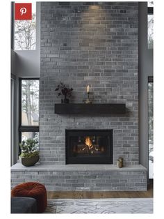 an image of a fireplace in the middle of a living room with grey brick walls