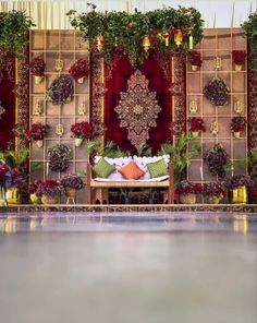 a stage set up with flowers and plants on it