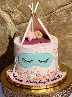 a birthday cake decorated with a tent and sleeping baby's face on top of it