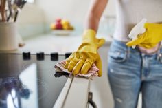 a pair of yellow gloves on top of a white counter next to a woman's legs