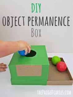 a child is playing with an object in the shape of a box that says diy object permanence box