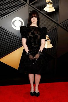 a woman standing on top of a red carpet