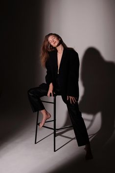 a woman sitting on top of a chair posing for the camera with her legs crossed