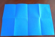 folded blue paper sitting on top of a wooden table