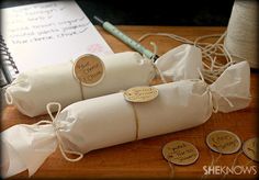 two rolls of white paper wrapped in twine on top of a wooden cutting board