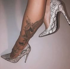 a woman's legs with tattoos and high heels