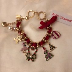 Cute Chunky Gold Tone Charm Bracelet Features A Red Ribbon Woven Throughout Bracelet And Tied In A Bow On One End. Includes 7 Dangling Charms: 1 Faux Pearl Snowman; 1 Gold Tone Gingerbread Man With Textured Detailing And Crystal Accents; 1 Gold Tone & Pink Enamel Flamingo With Santa Hat & White Faux Pearl On Top Of Hat; 1 Gold Tone Green & Red Striped Candy Cane Heart With Green Metal Bow & White Faux Pearl Accent In Center Of Bow; 1 Rose Gold Christmas Tree With Red Crystal Star & Crystal Accen Charm Bracelet Aesthetic, Pearl Snowman, Candy Cane Heart, Rose Gold Christmas Tree, Cat Charm Bracelet, Bracelet Aesthetic, Red Charm, Metal Bow, Star Crystal