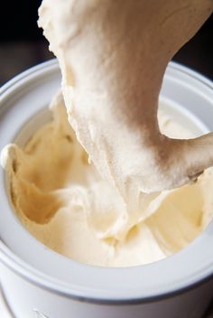 a white cup filled with cream sitting on top of a table