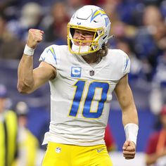 a close up of a football player wearing a helmet and holding his fist in the air