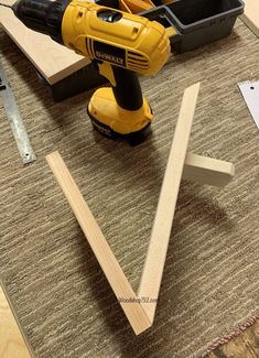 a cordless driller sitting on top of a table next to some pieces of wood