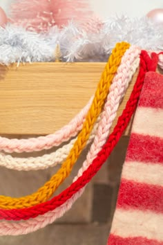 there is a red and white striped sock hanging from a clothes line next to a christmas tree