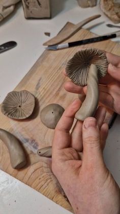 a person is carving mushrooms on a wooden board