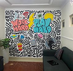 a living room with graffiti on the wall and couches in front of an air conditioner