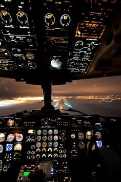 an airplane cockpit with the lights on at night, and it's view from inside