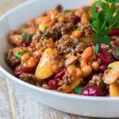 a close up of a bowl of food with meat and vegetables in it on a table