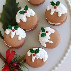 small cookies decorated with icing and holly leaves on a plate