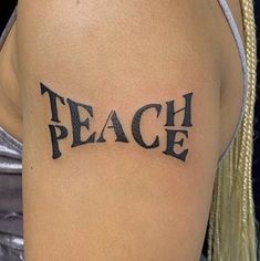 a woman's arm with the word peace tattooed on her left shoulder and chest