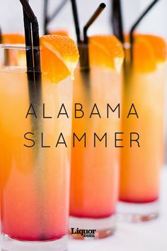 three glasses filled with orange and black straws sitting on top of a table next to each other