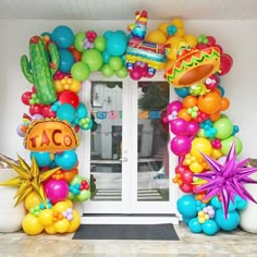 an entrance decorated with balloons and decorations for a mexican themed birthday or baby's first birthday