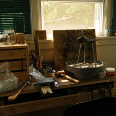 a cluttered workbench in front of a window