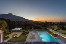 an aerial view of a pool and patio at dusk