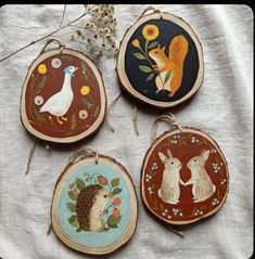 four hand painted wooden ornaments with animals and flowers