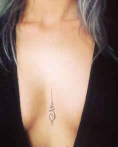 a close up of a woman's chest with a tattoo on her left side