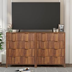 a flat screen tv sitting on top of a wooden dresser