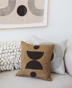 a couch with two pillows and a painting on the wall