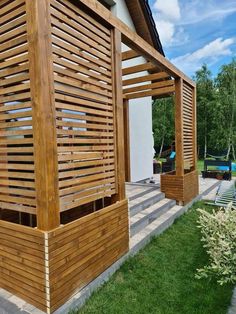 a wooden structure sitting on top of a lush green field next to a swimming pool