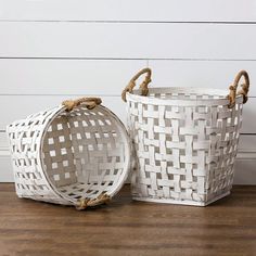 two white baskets sitting on top of a wooden floor