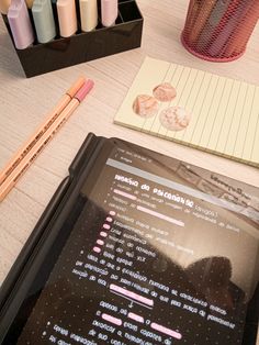 a tablet computer sitting on top of a desk next to some markers and pencils