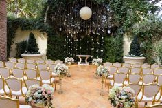 an outdoor ceremony setup with gold chairs and flowers