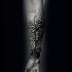 a black and white photo of a person's arm with a tree on it