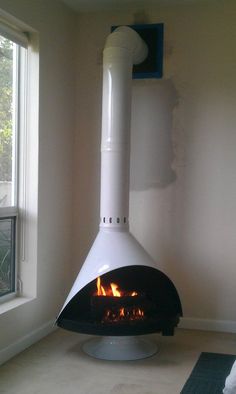 a large white stove sitting in a room next to a window on top of a rug