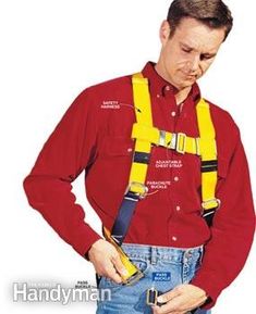 a man wearing a red shirt and yellow safety harness with his hands in his pockets