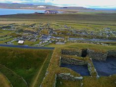 an aerial view of the ruins and surrounding fields with water in the distance, near a large body of water