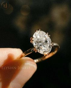 a person holding a diamond ring in their hand