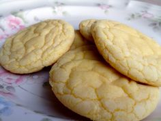 three cookies sitting on top of a white and pink plate next to each other with flowers